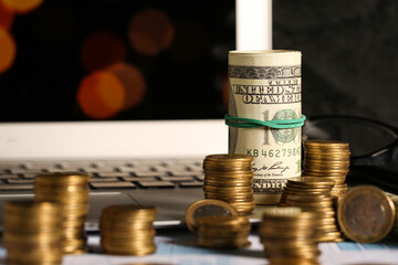 Golden coins with dollars on table near screen of computer