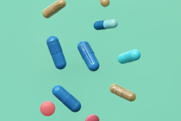 Flying different pills on turquoise background