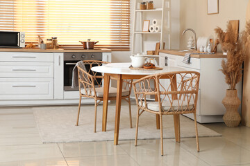 Interior of kitchen with teapot, tasty poppy buns and jar of sugar on table