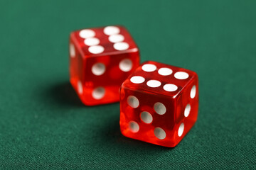 Red game dices on green background, closeup