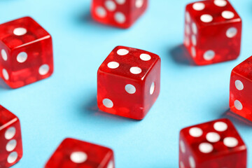 Red game dices on blue background, closeup