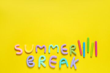 Text SUMMER BREAK made of play dough and markers on yellow background