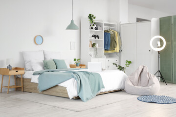 Interior of teenager's room with bed, ring light and closet