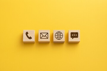 Contact Us: Wooden blocks with contact icons on yellow background.