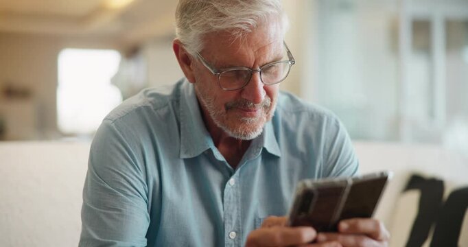 Senior man, home and phone text on sofa with online puzzle game, blog and digital news in retirement. Morning, mobile and app scroll with technology in a lounge with website search and relax in house