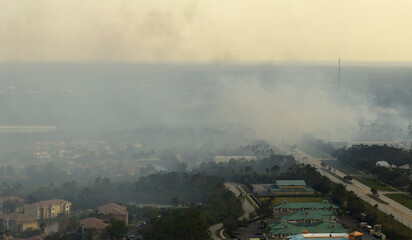 Aerial view of strong wildfire burning severely in North Port city, Florida. Natural disaster during dry season in jungle woods