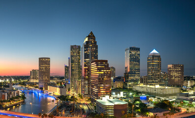 Fototapeta premium American city skyline with brightly illuminated high commercial buildings and streets. Night urban landscape of downtown district of Tampa in Florida, USA.