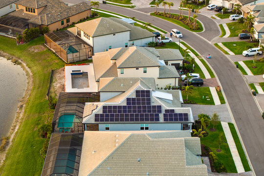 American building roof with rows of blue solar photovoltaic panels for producing clean ecological electric energy. Renewable electricity with zero emission concept