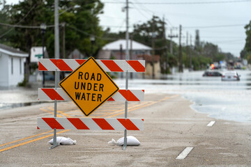 Hurricane Debby flooded street with road closed sign blocking driving of cars in Sarasota, Florida....