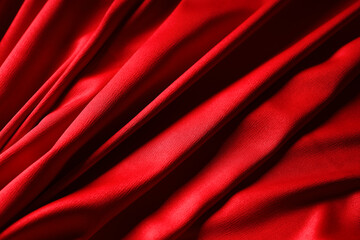 Red fabric with folds as background, closeup