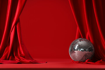 Open red curtains with disco ball on color background
