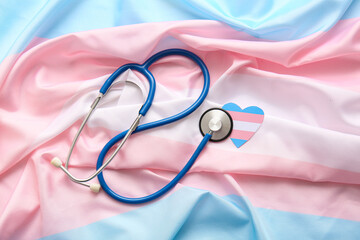Paper heart with stethoscope on transgender flag