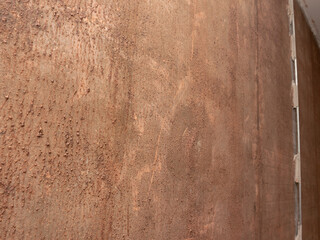 A wall with a brownish color and a rough texture
