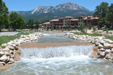 Mountain retreat featuring a cascading stream and scenic mountain views with architectural style