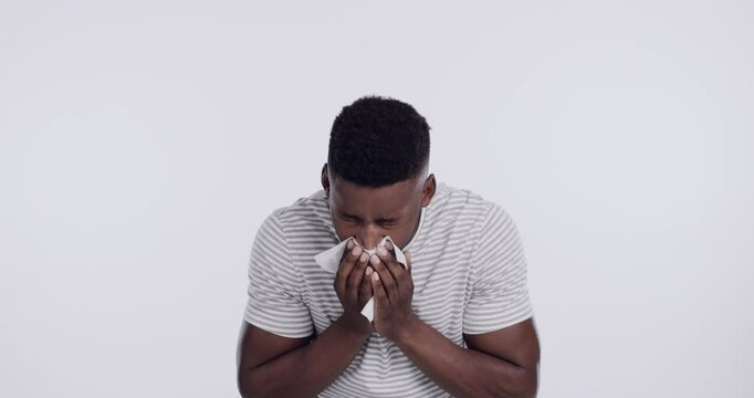 Man, sneeze and tissue or sick in studio for allergy season or virus for flu problem, allergies or hayfever. Black person, toilet paper and bacteria health for white background, congestion or mockup