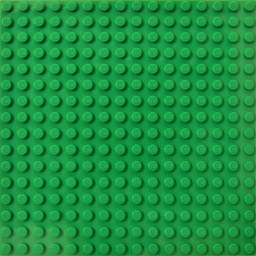 Lego green baseplate with rows of round knots to assembly plastic bricks from popular toy brand. Editorial illustrative image of popular children plastic toy.