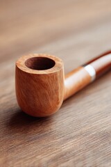 solitary pipe resting on plain wooden surface symbolizes traditional father day gift