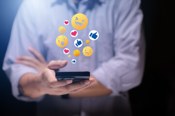 Close-up of man's hand using smartphone to play social media with emoticons or notifications popup.	

