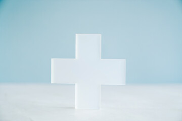 Obraz premium Plus cross model on blue background, medical healthcare, wellness support, positivity concept