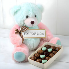 teddy bear sitting next to a gift bag with beautiful flowers for mother