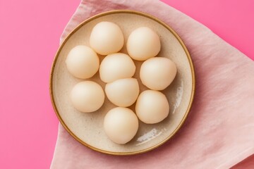 A plate of pale-yellow, round, sweet treats.
