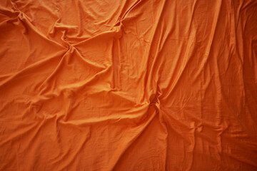 Bright orange fabric draped with natural folds and creases
