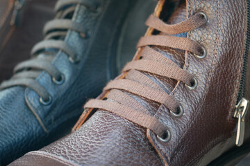 Laces neatly tied on brown and black leather shoes displayed in a shop