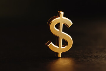 shiny gold dollar sign stands prominently against dark background, symbolizing wealth and prosperity. Its reflective surface captures light, adding sense of luxury and allure