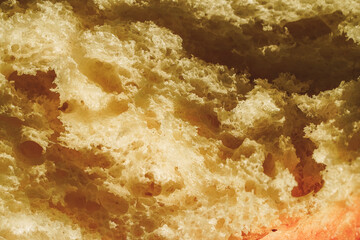 Close-up of a French baguette with sesame seeds. Background with bread texture. Dried wheat loaf, macro photography. Use for banner, menu