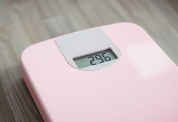 Pink Digital Bathroom Scale Showing Weight Measurement on Wooden Surface A Close up View of a Modern Weight Scale