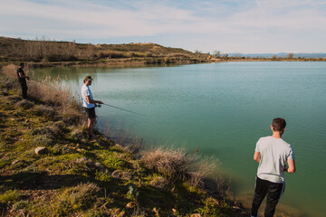 Naklejka premium Group of Friends Fishing Together by Calm Lake