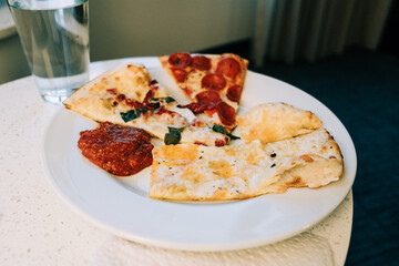 Dining on pizza slices with dipping sauce and water
