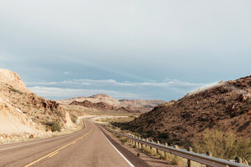Winding desert highway cuts through rocky hills in West Texas
