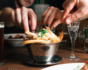 friends taking fries together in a restaurant