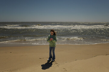 Beautiful tween using cell phone on beach vacation