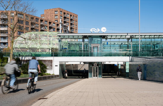 Cyclists ride under the bicycle tunnel under the railway station. On the left the Bike Apple, a bicycle parking facility in Alphen aan den Rijn, the Netherlands, April 07 2025