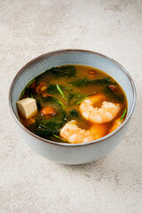 A bowl of shrimp, greens, and tofu offers a warm, flavorful soup that's comforting