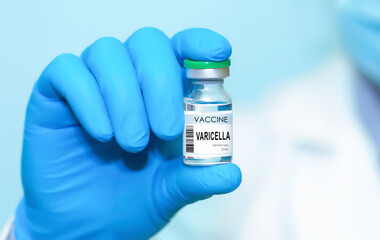 Doctor wearing protective medical gloves holding a bottle of Varicella vaccine, representing modern medicine, disease prevention, scientific research, and global vaccination awareness.