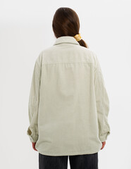 Back view of a casual woman standing with her hands down and thinking about something. Woman standing with her back in a white shirt