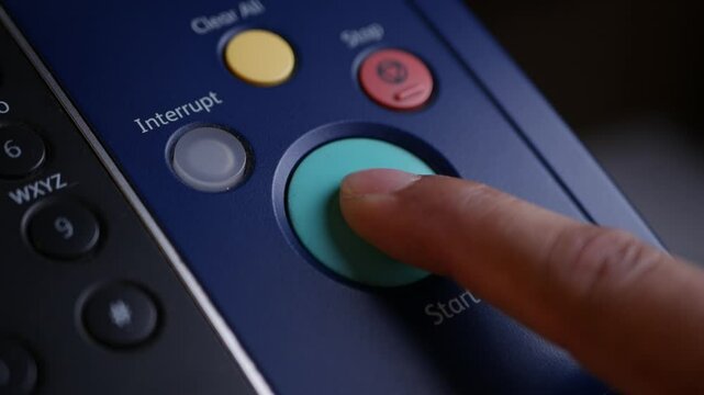 Close up hand office man press start button on panel to using the Office professional multi-function printer scanner for scanning document printing. a Copy machines