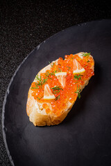 Savory treat showcases vibrant salmon roe topped with fresh herbs and zesty citrus on bread