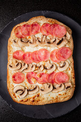 Layers of salami and mushrooms adorn a delicious crust, ready to be enjoyed at a festive gathering