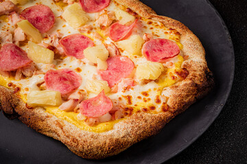 Enjoy the delicious ham and pineapple pizza with a golden crust, great for sharing!