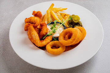 A tempting assortment of fried shrimp and onion rings served with crispy fries and fresh jalapenos