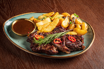 Delicious grilled steak with chili and rosemary, served with crispy potatoes and sauce
