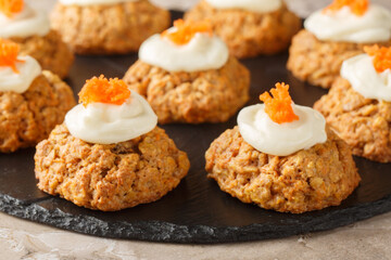 Healthy Carrot Oatmeal Cookies with Cheese Frosting Close-up on Plate on Table. Horizontal