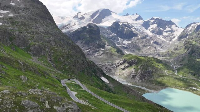Flight towards Stein Glacier and mountain panorama revealing the serpentine road of mountain pass Susten Pass in the Swiss Alps, Switzerland