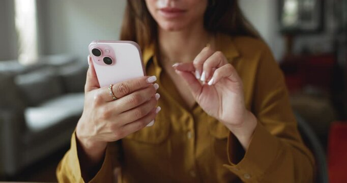 Close up of young woman holding smartphone, looking at screen and typing message, chatting with friend or colleague, checking emails, browsing website or new mobile app, replying to text or comment