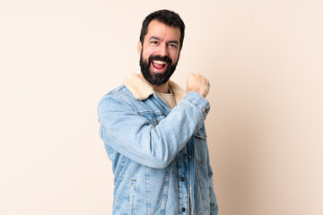 Caucasian man with beard over isolated background celebrating a victory