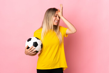 Young football player woman isolated on pink background having doubts with confuse face expression